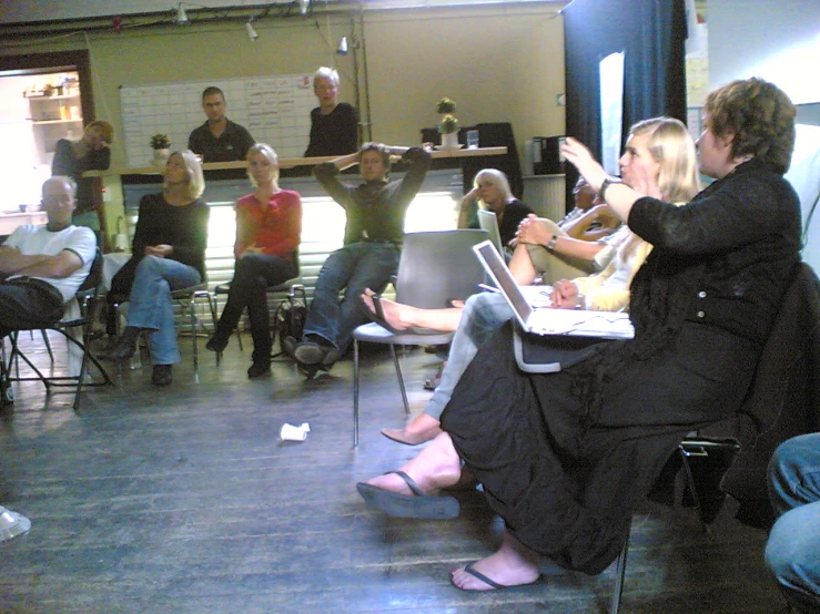 people sitting in a room, all using laptops