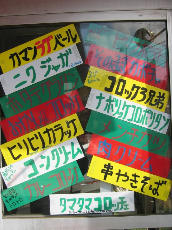 a group of different colored signs sitting inside a window