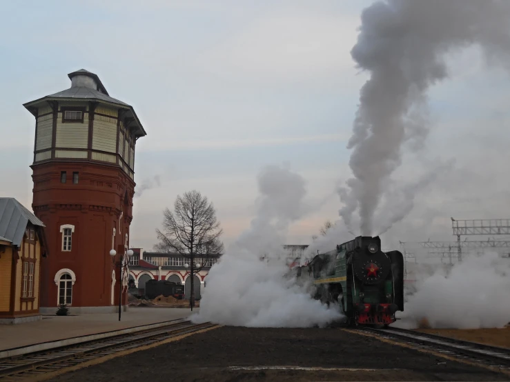 two trains pulling into a station surrounded by smoke