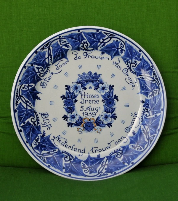 an ornate blue and white plate on green fabric