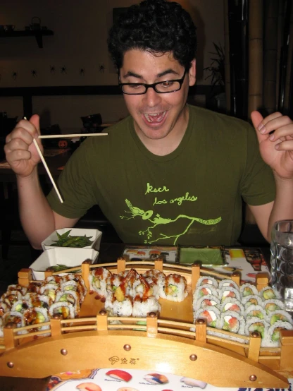 a man holding chopsticks and some sushi