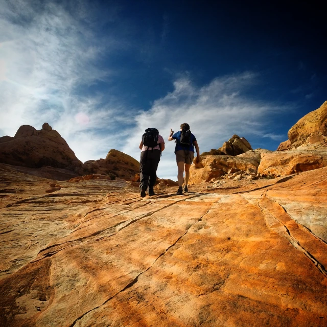 two hikers walking up a rocky trail among large rocks
