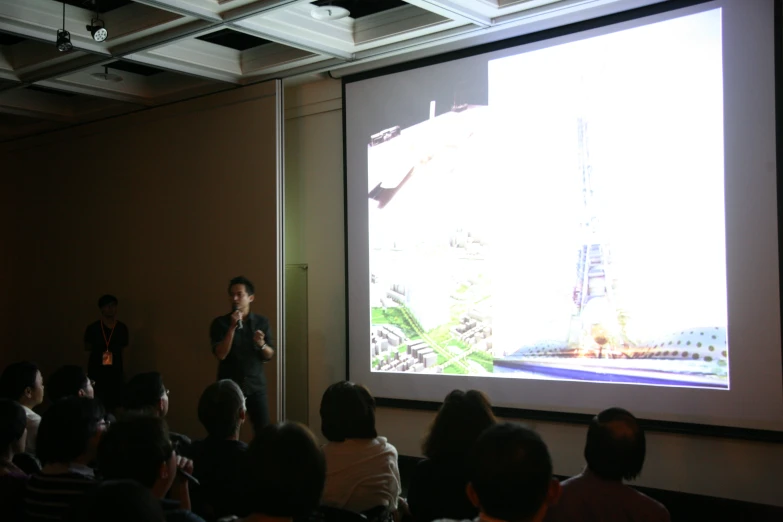 people watching an presentation on a screen with a projection