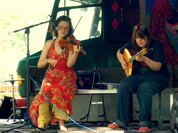 two people that are playing music on the ground