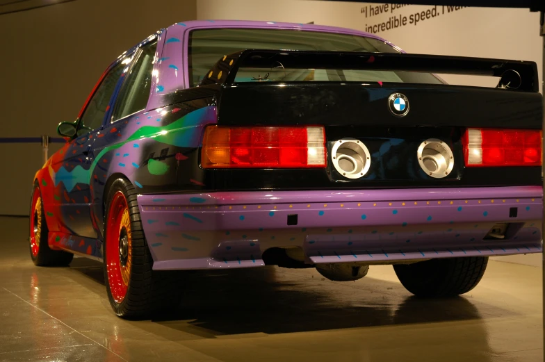 the rear of a colorful bmw car in an exhibit