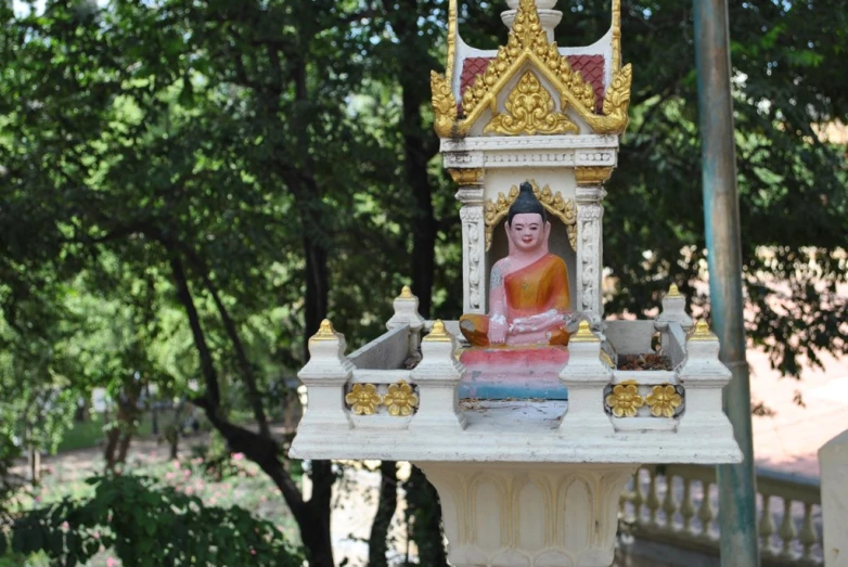 an elaborate golden and white clock in a park