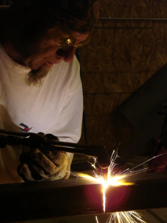 a man welding in the dark with his arms spread apart