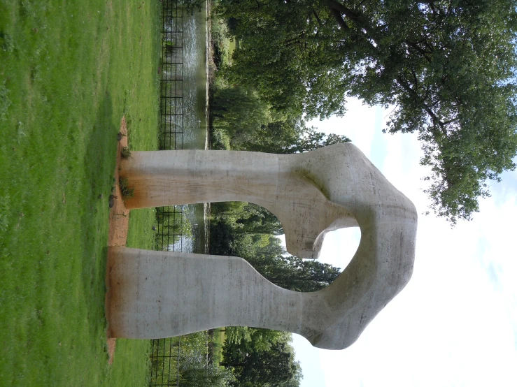 a white sculpture with a heart shape placed next to a grassy field