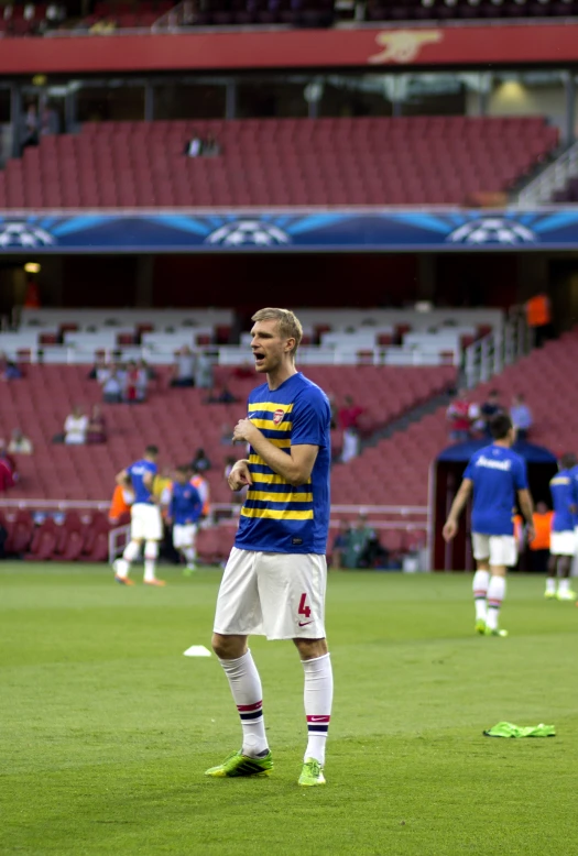 a man wearing shorts stands on the side of a field