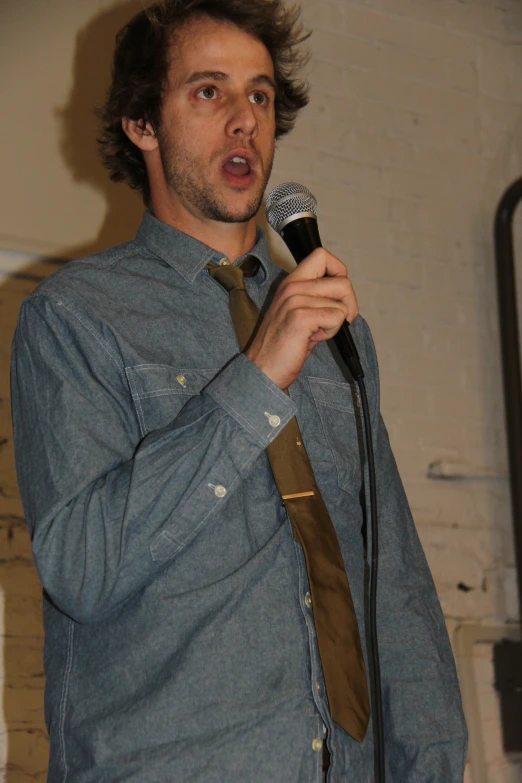 a man is standing up and speaking into a microphone