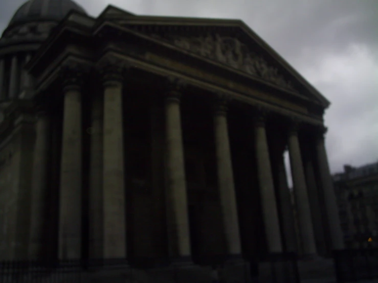 the side of a building with two pillars and the top of the structure painted grey