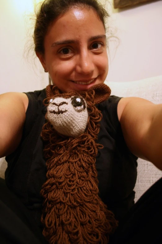 woman smiling while she is wearing an alpaca scarf