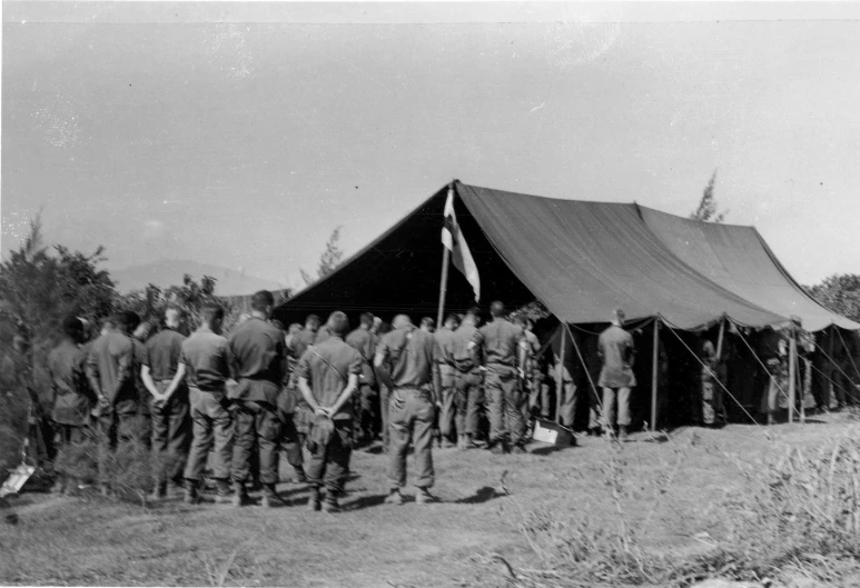 soldiers standing in front of an awning while talking to soldiers