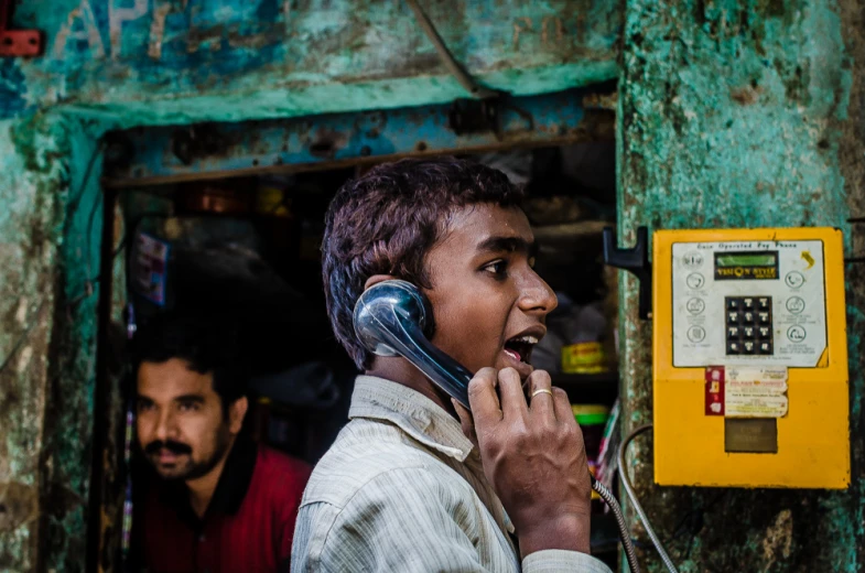 the man in the striped shirt is on the telephone