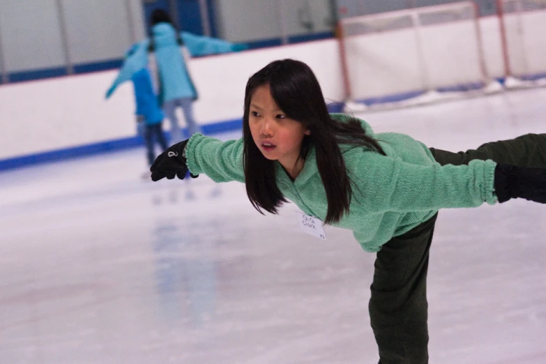 a girl is skating on an ice rink
