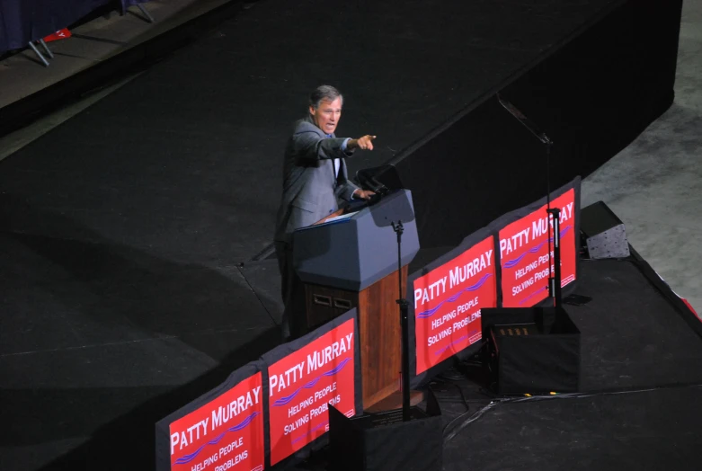 a man in a suit and tie talking on stage