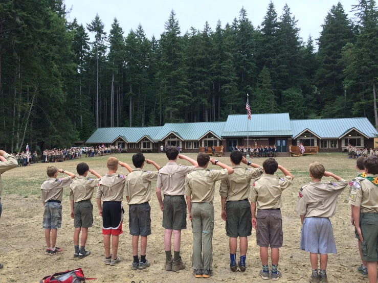 a group of boys in scout uniforms watching soing