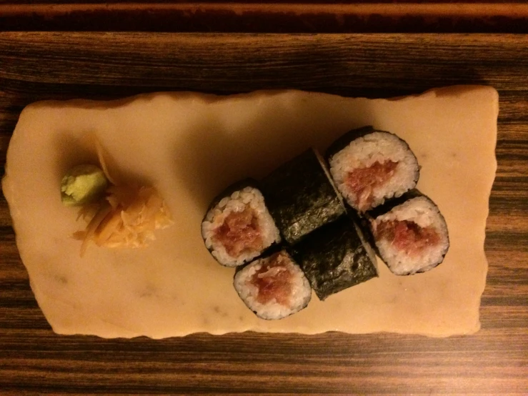 sushi on a wooden table with vegetables and sauces