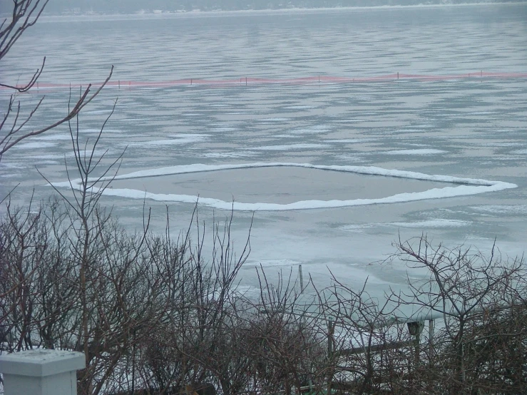 a circular bench sits in the middle of an icy lake
