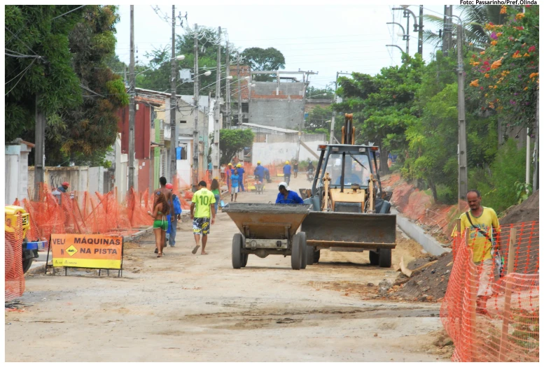 several people in safety gear are walking past construction work