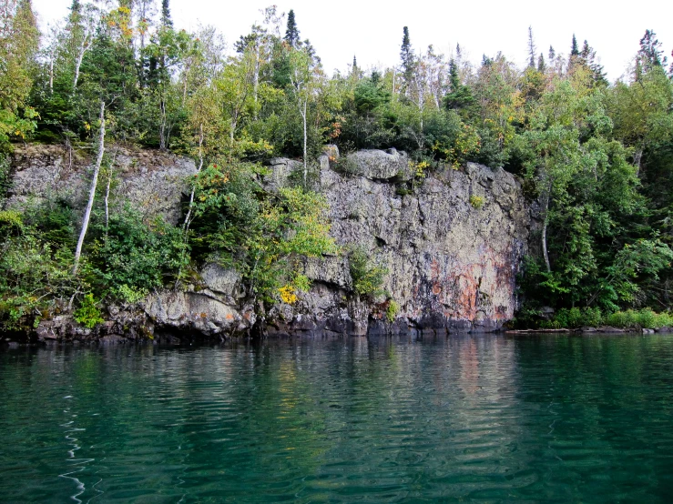 the water is blue and murky with a few trees on it