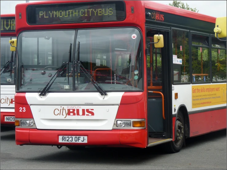 the buses are driving down the road with their doors open