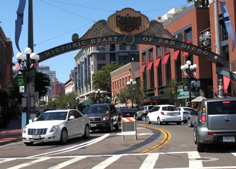 cars driving under an arch that says the main street