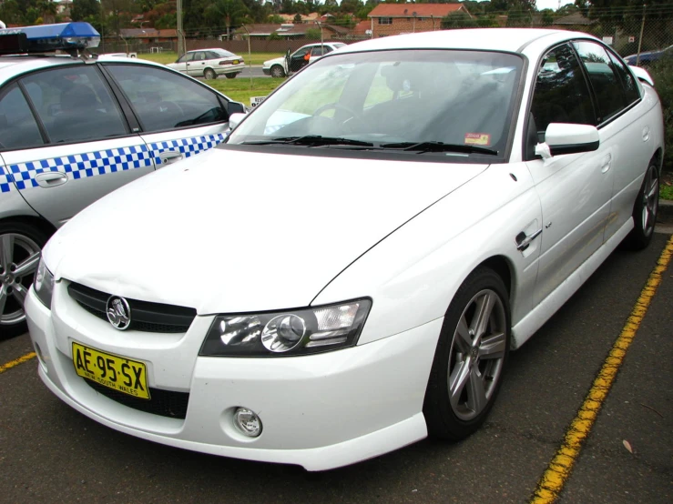 a white car parked next to two other cars