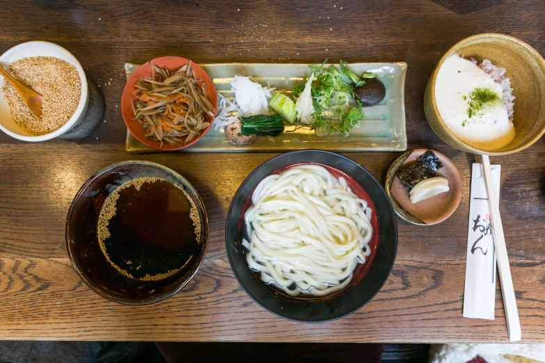 bowls of food and chopsticks are on the table