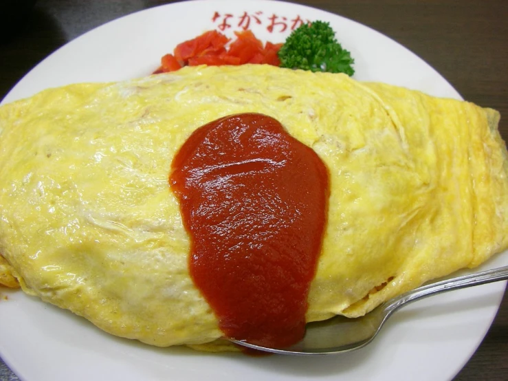 an omelet is placed on the plate with sauce