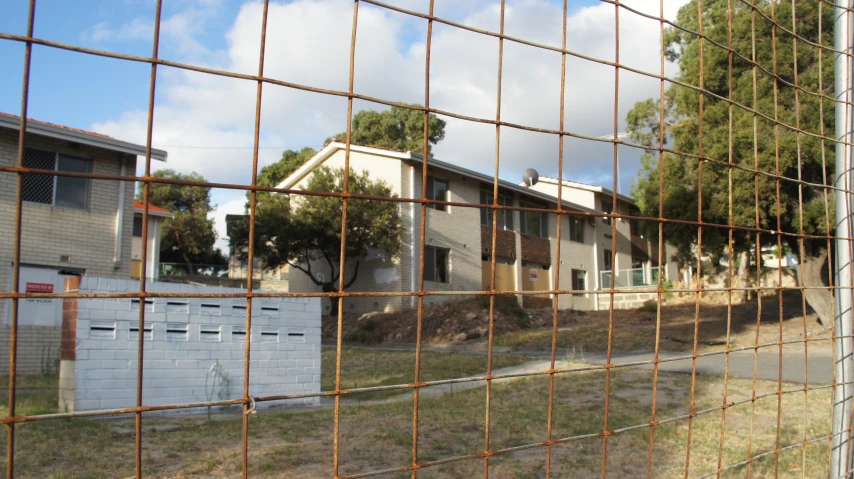 a building is seen through a wire fence