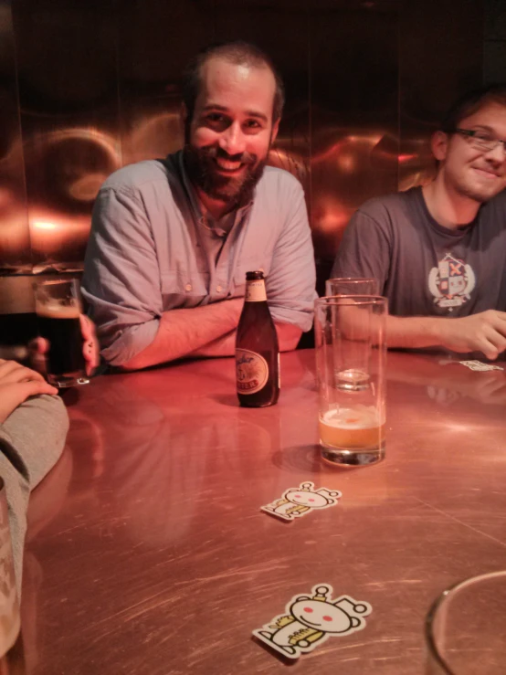 three men are having drinks at a beer