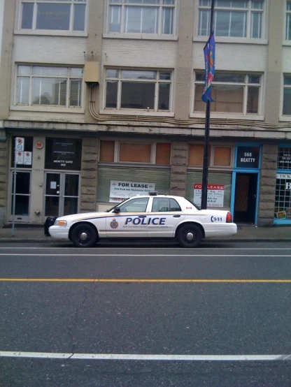 police car parked in front of store on street