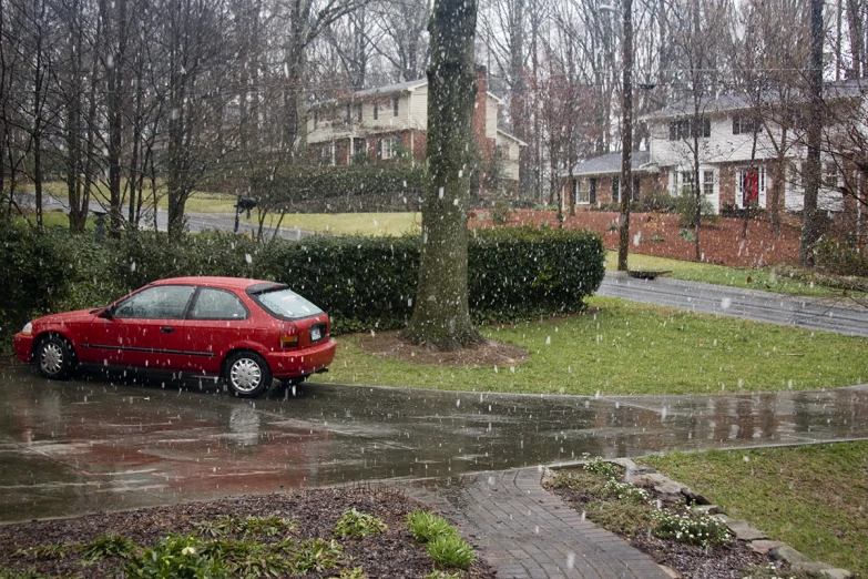 a red car parked in the rain