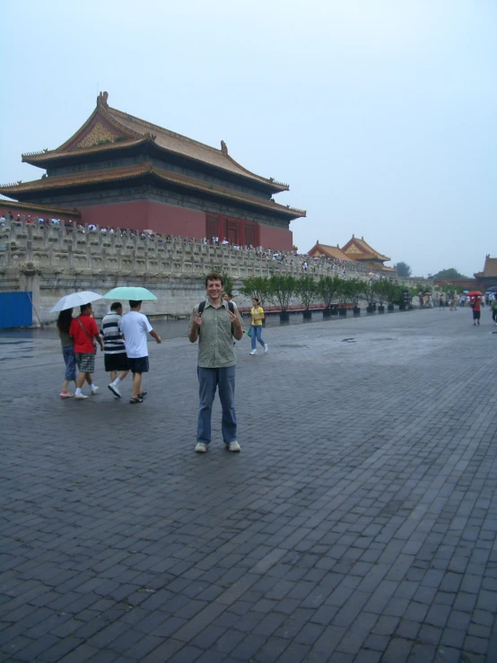 two men standing in front of the forbidden city wall