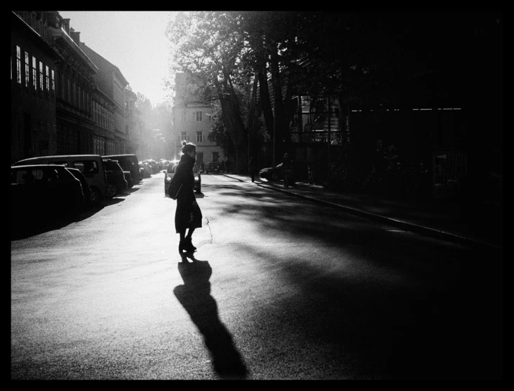 a black and white po of a person walking down a street