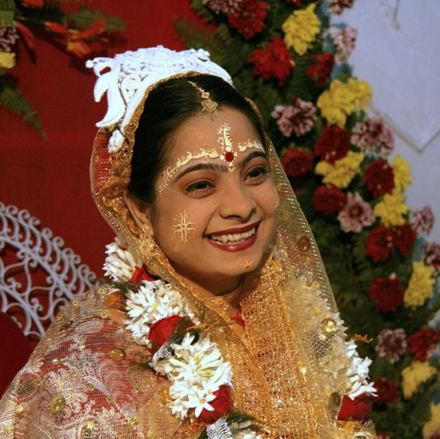 a smiling woman wearing traditional garb and flowers on her head