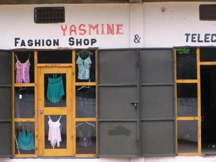 an outside view of a store with shirts and ties in the windows