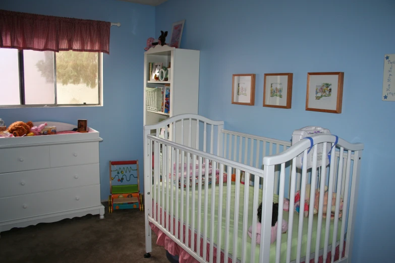 a white crib in a small room with blue walls