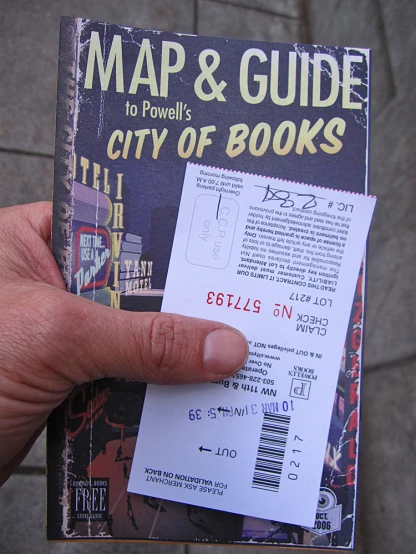 a person is holding a map and guide in front of a building