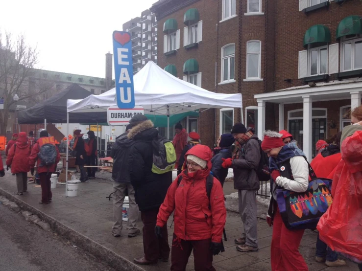 there are many people standing outside with red coats