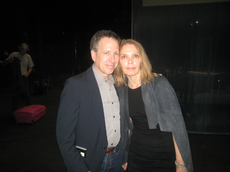 a man and woman pose for a picture at night