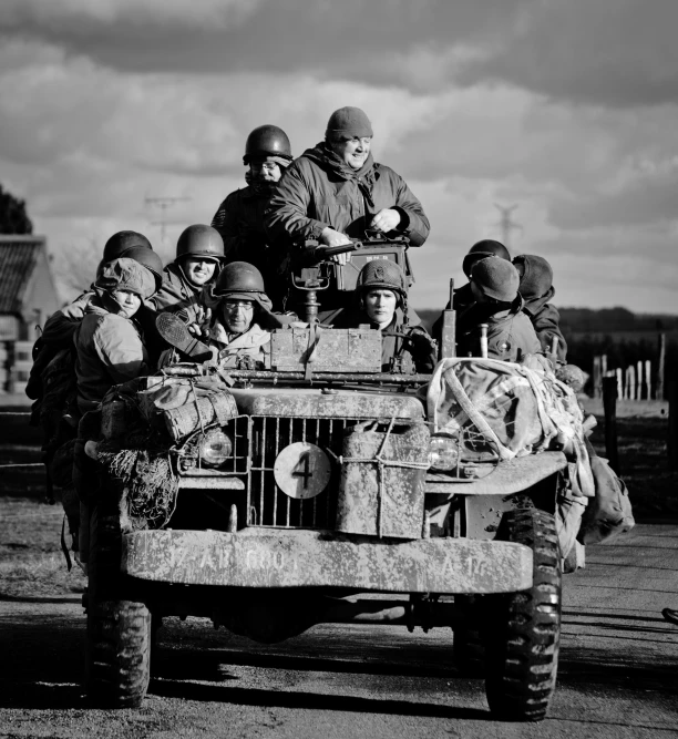 the soldiers are sitting on top of an old truck