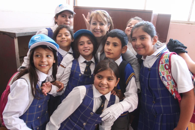 a bunch of s standing in school uniforms posing for a picture