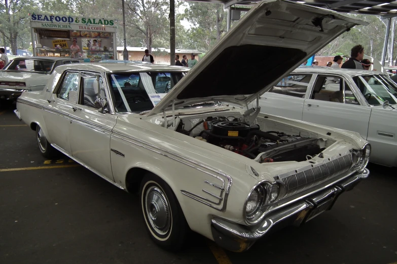 an old white car with its hood open