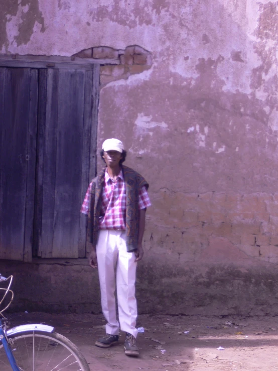 a man in plaid and white is standing by a door