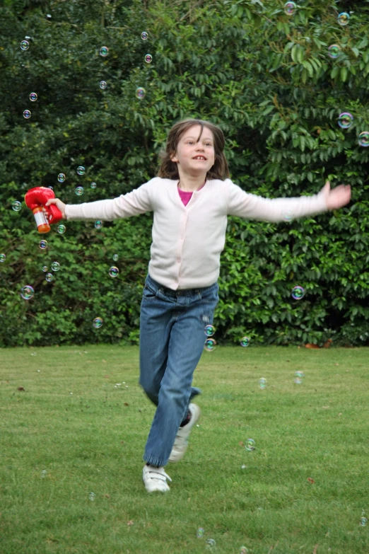  running through a park with her arms stretched out to catch a ball