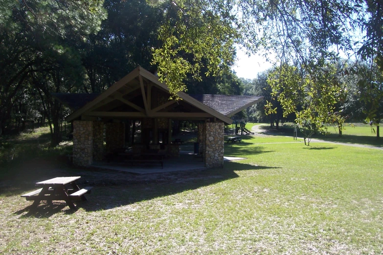 a pavilion in the park with picnic benches next to it