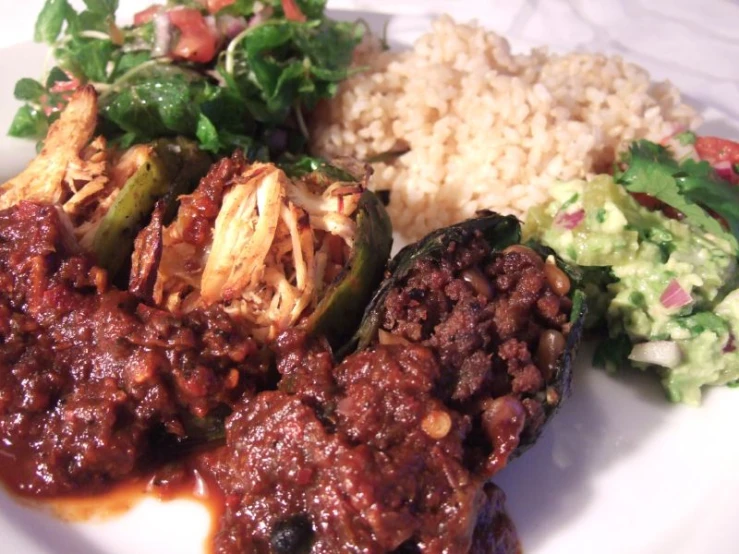 a white plate with stuffed peppers and rice