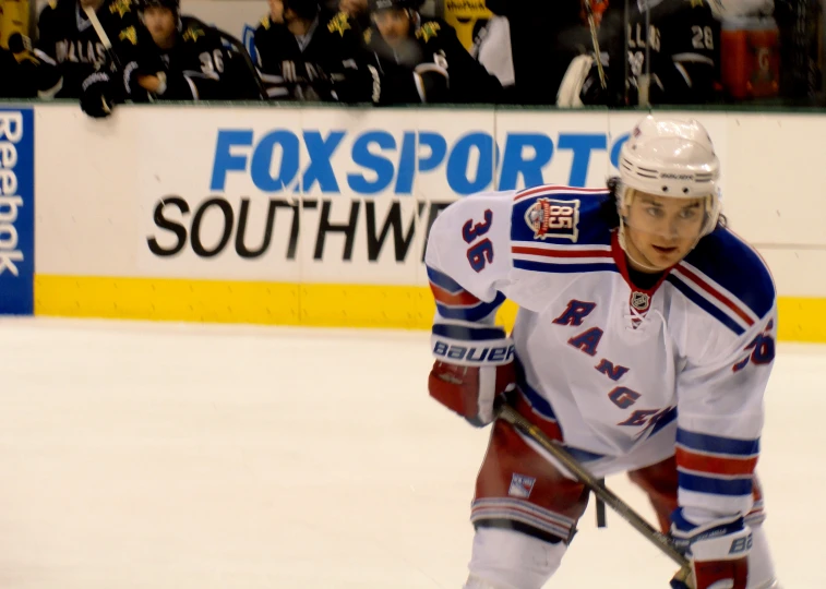 a hockey player with the rangers is holding a stick